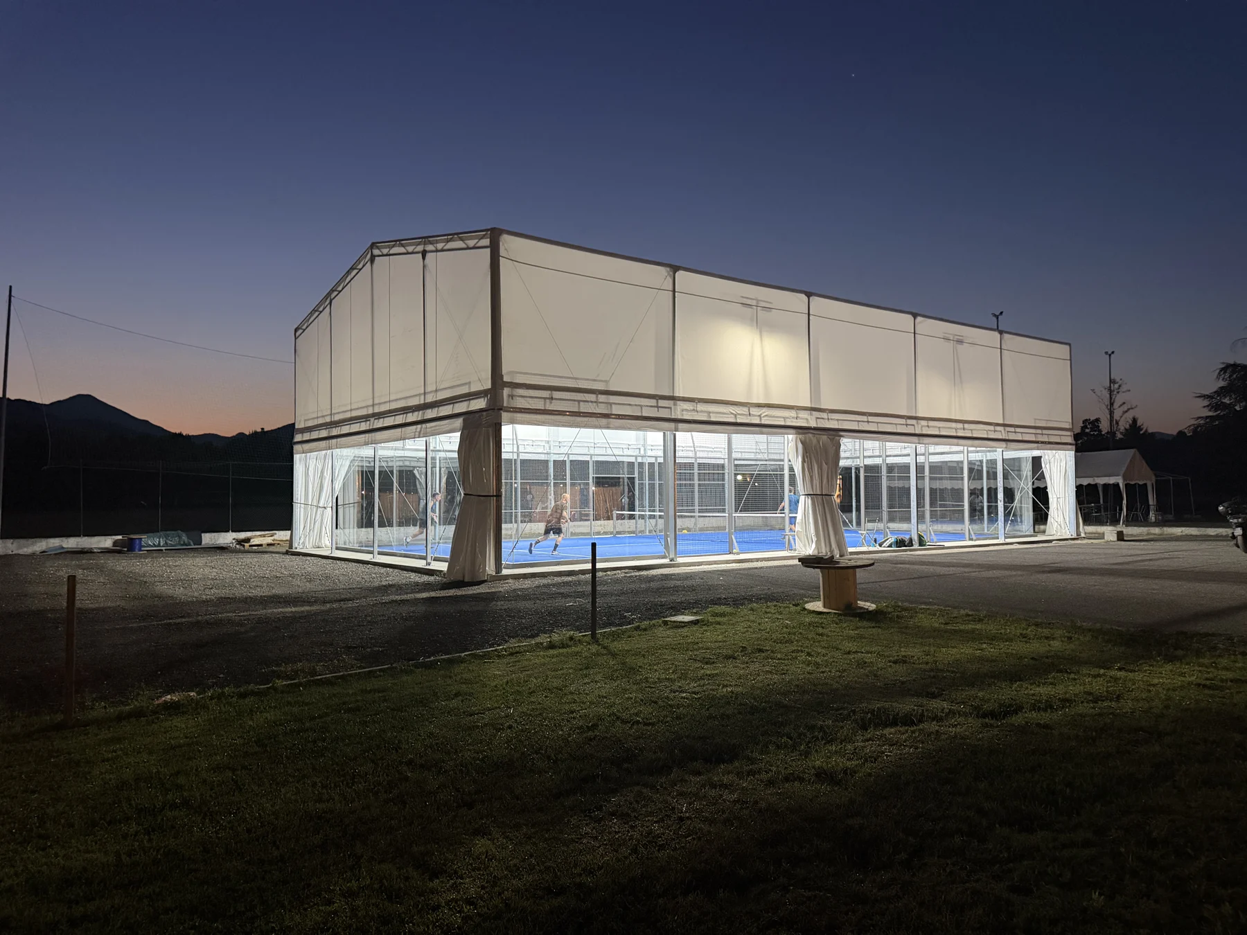 La copertura completata di Lunigiana Padel, illuminata di sera